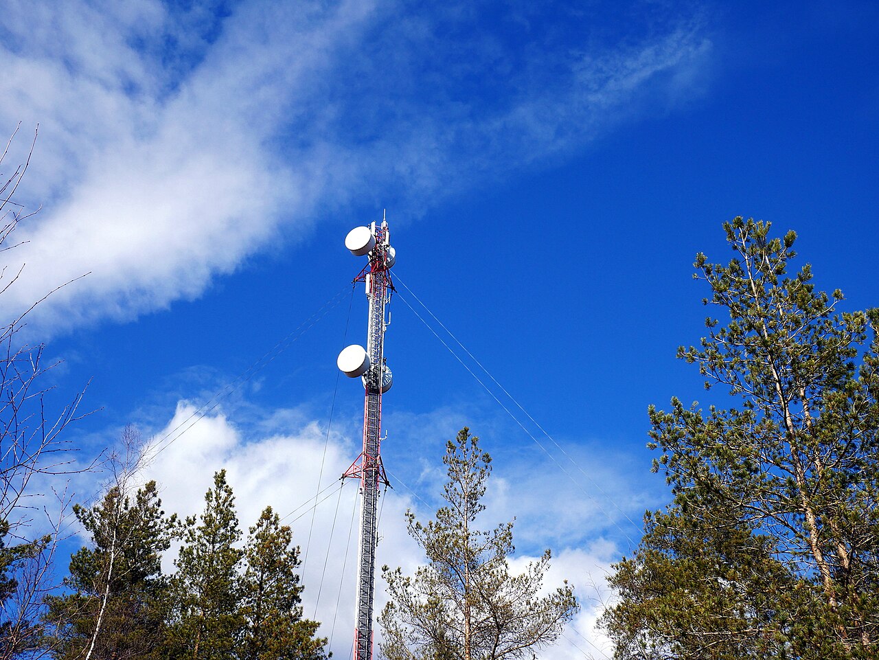 Antennes d’un réseau mobile sur un pylône en Finlande, sous un ciel bleu, en 2017.