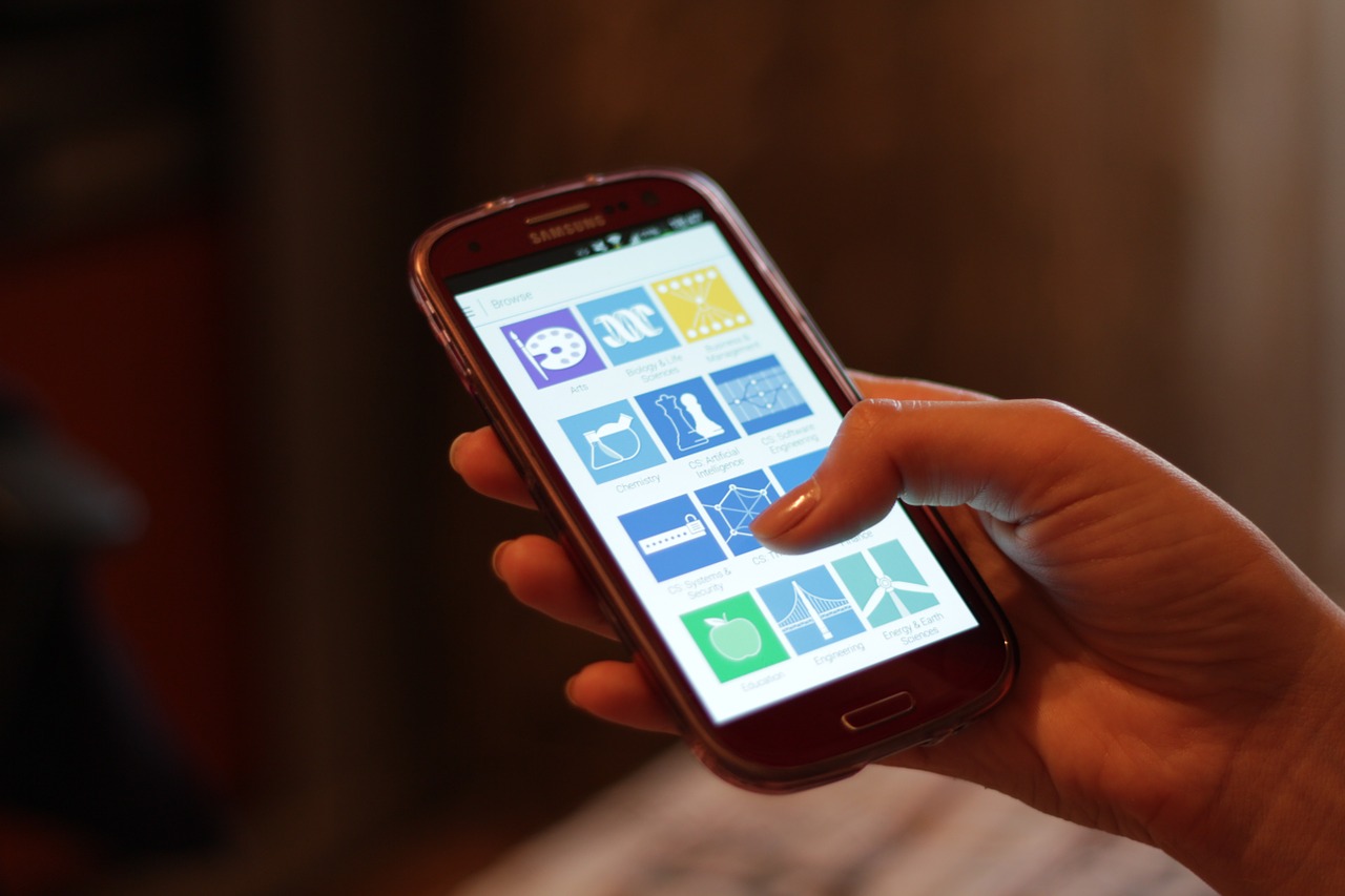 Main utilisant un smartphone, photographie d’illustration de 2015 sans lien avec le bootcamp M-PESA.