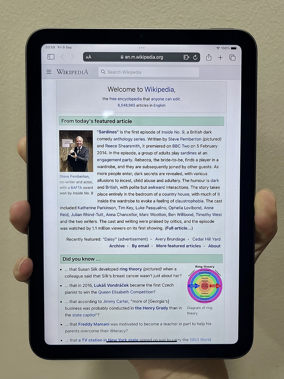 iPad mini de sixième génération tenu dans une main, photographie d’archive de 2022, distinct du modèle annoncé en 2026.