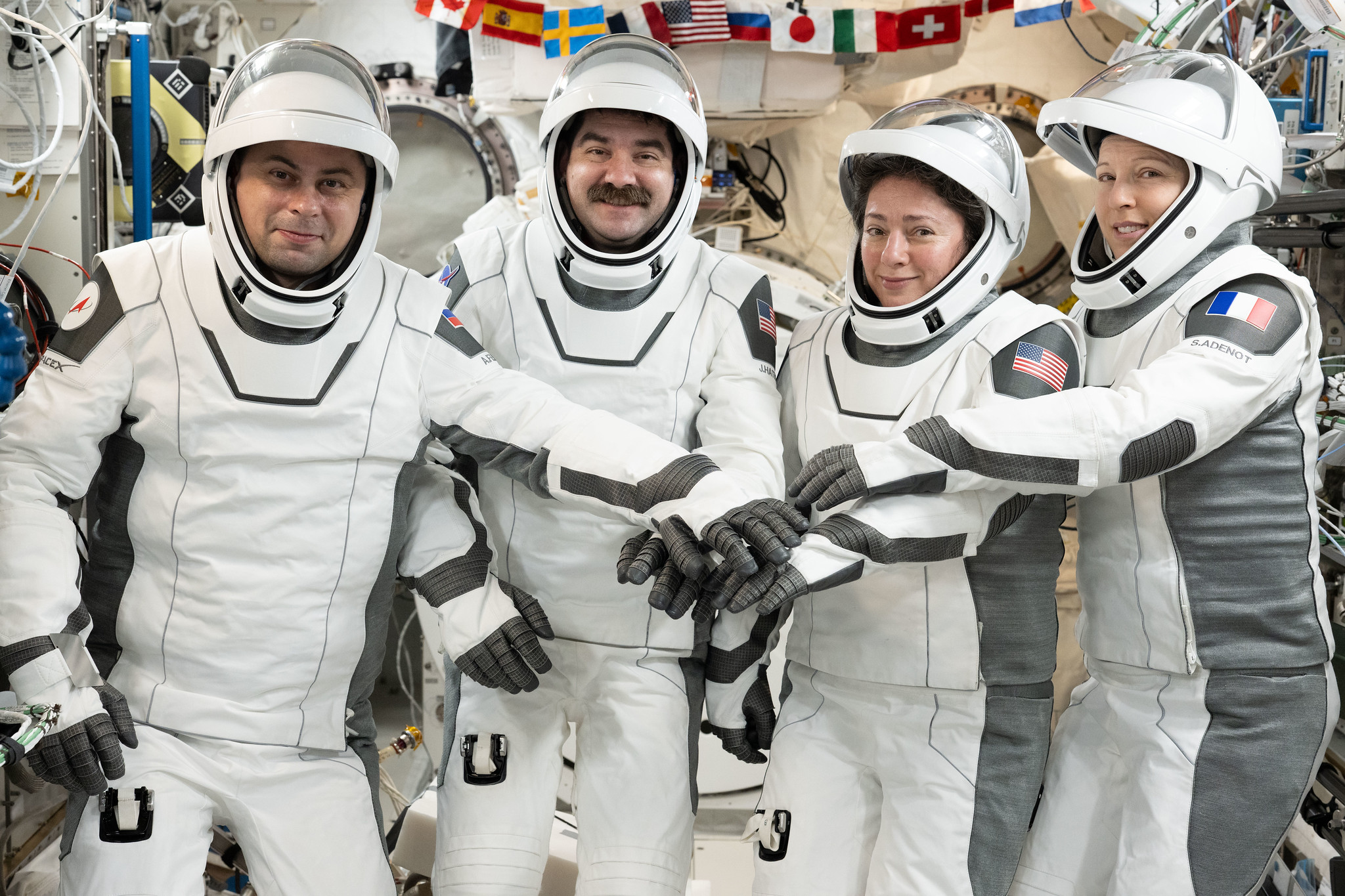 Les quatre membres de Crew-12 en combinaison à bord de l’ISS, réunis pour un portrait de groupe.