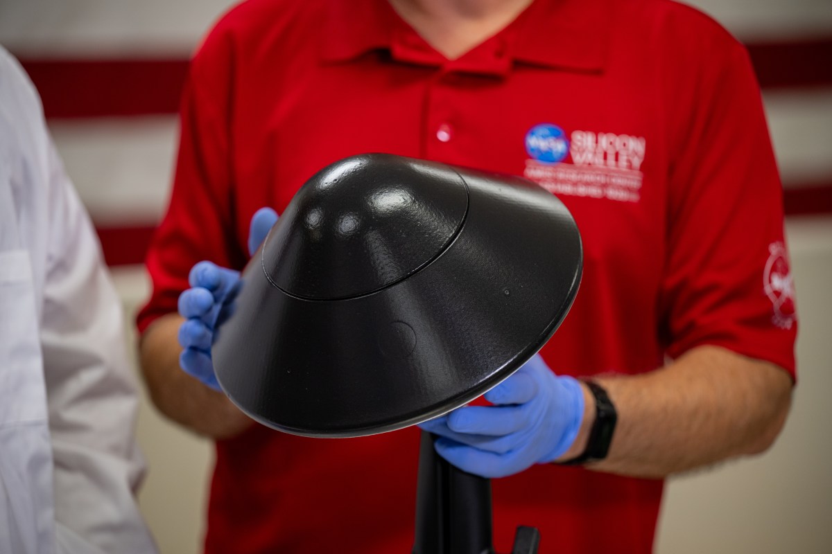 Bouclier thermique KREPE noir tenu avec des gants au laboratoire Ames de la NASA.